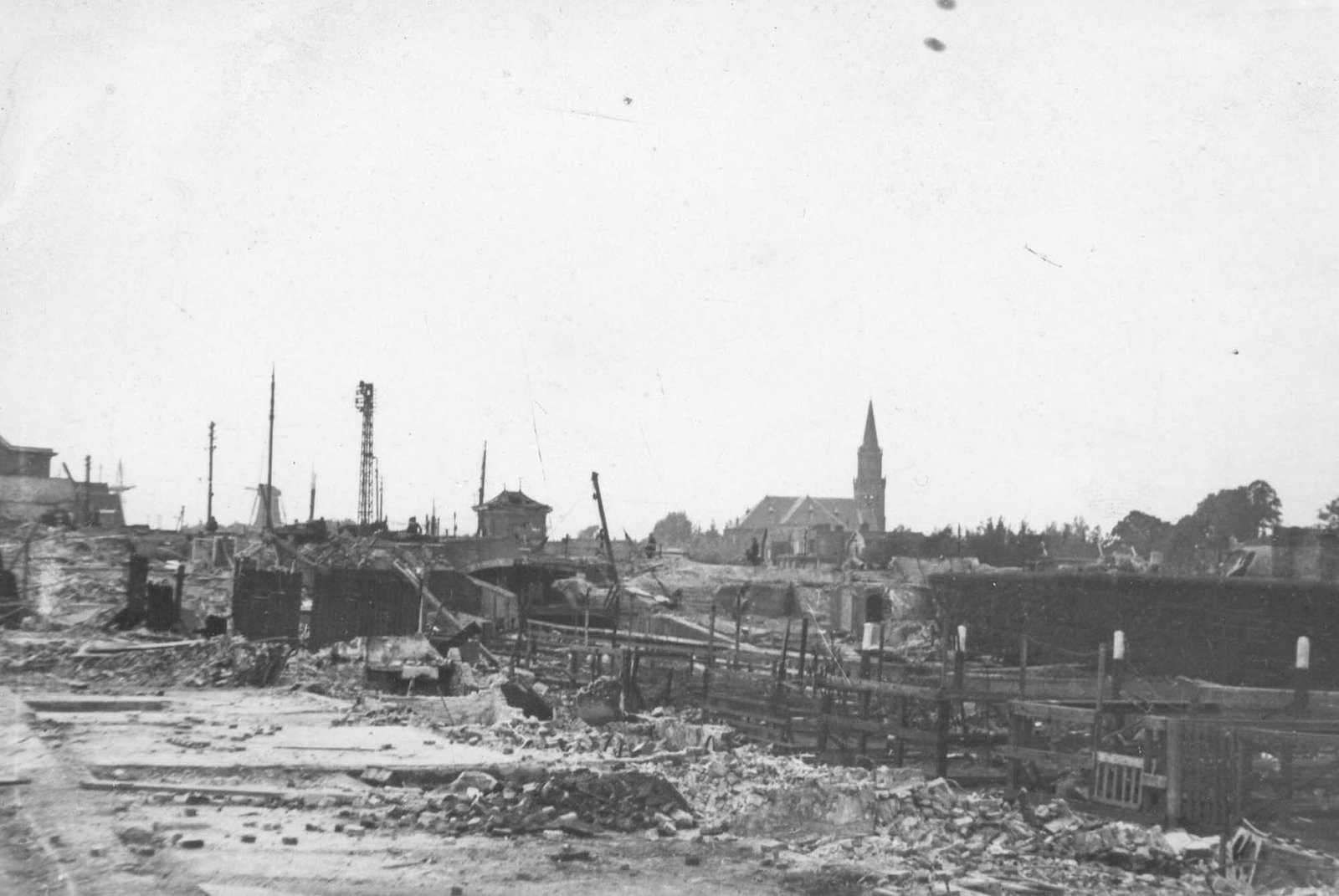 De Polderstraat richting de dam, met op de achtergrond de toren van de grote kerk. Rechts zijn de reeds afgebroken huizen van de Oude en Nieuwe Kazerne